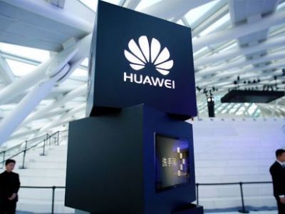 Сотрудники службы безопасности стоят возле колонны с логотипом Huawei на церемонии запуска в Пекине. Фото: Марк Шифельбейн